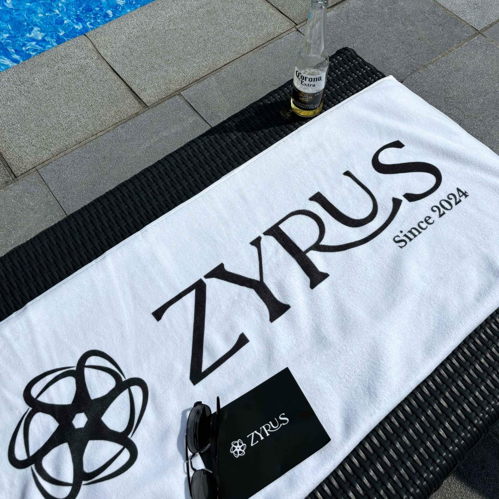 Zyrus lifestyle card with towel and sun vacation setting, showcasing a relaxed summer vibe.