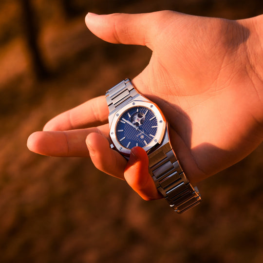 Zyrus Open Heart Watch in silver, elegantly showcased against a sunset background, blending sophistication with timeless design.